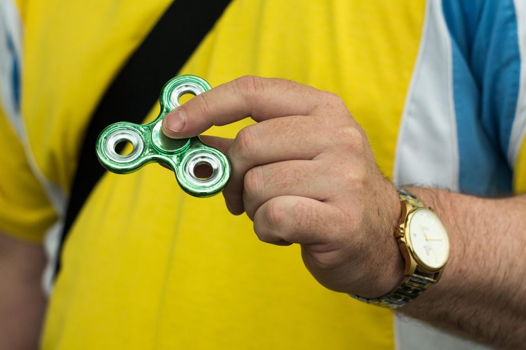 Fidget spinner diputar di tangan orang dewasa untuk relaksasi